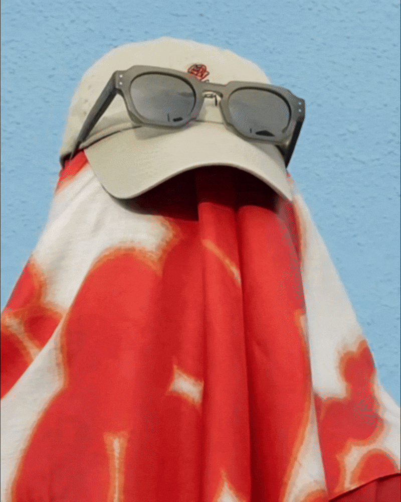 Back of the man wearing dopamine colorful red and off white cute floral bandana silk scarf with a beige cap and sunglasses in front of light background. Product video GIF file.