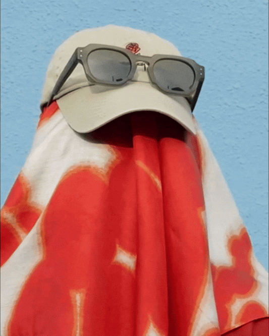 Back of the man wearing dopamine colorful red and off white cute floral bandana silk scarf with a beige cap and sunglasses in front of light background. Product video GIF file.