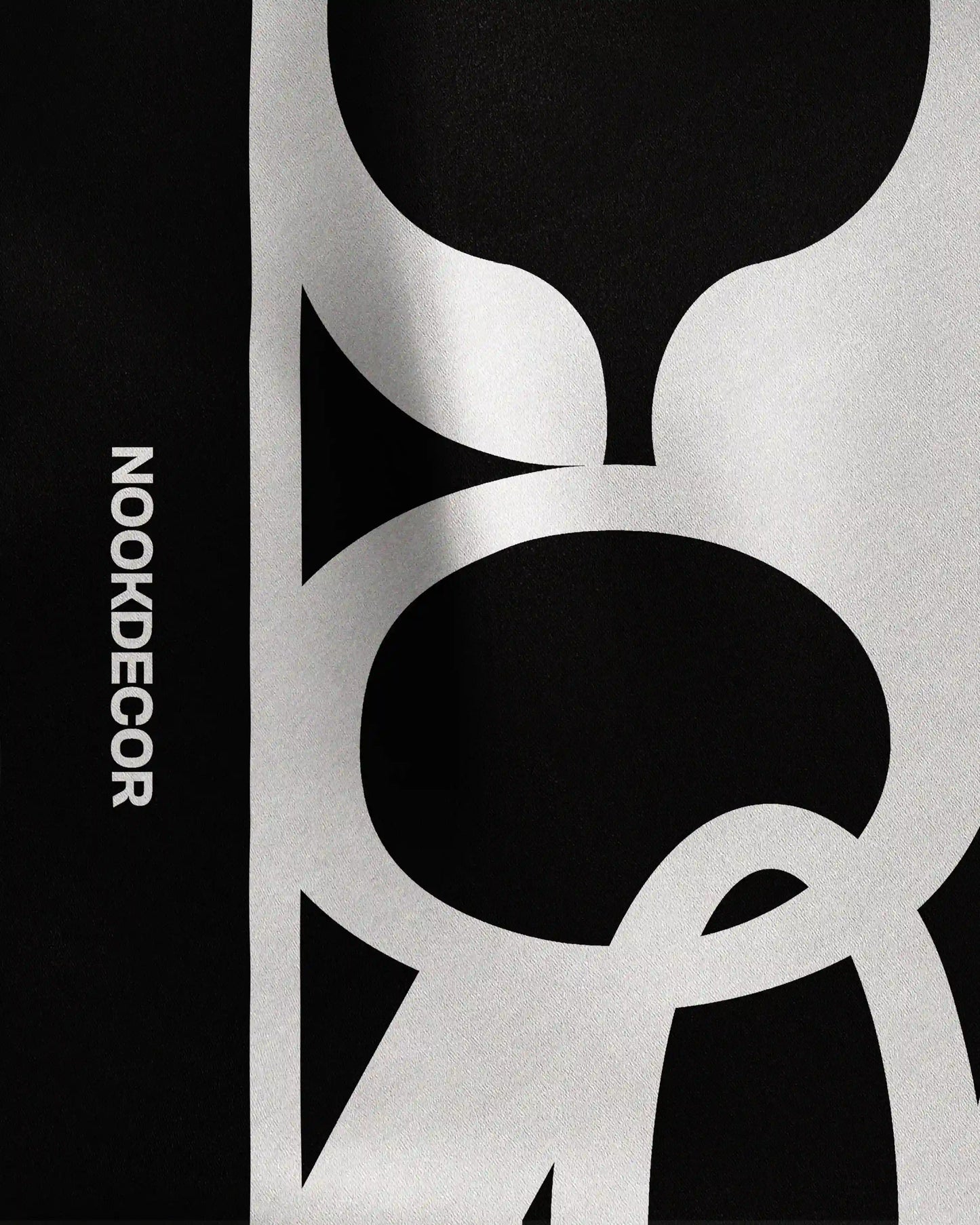 Detail of the intricate NOOKDECOR’s logo design on this 100% mulberry silk bandana in black and white, highlighting its quality as a luxury and chic twilly scarf and statement colorful accessory.