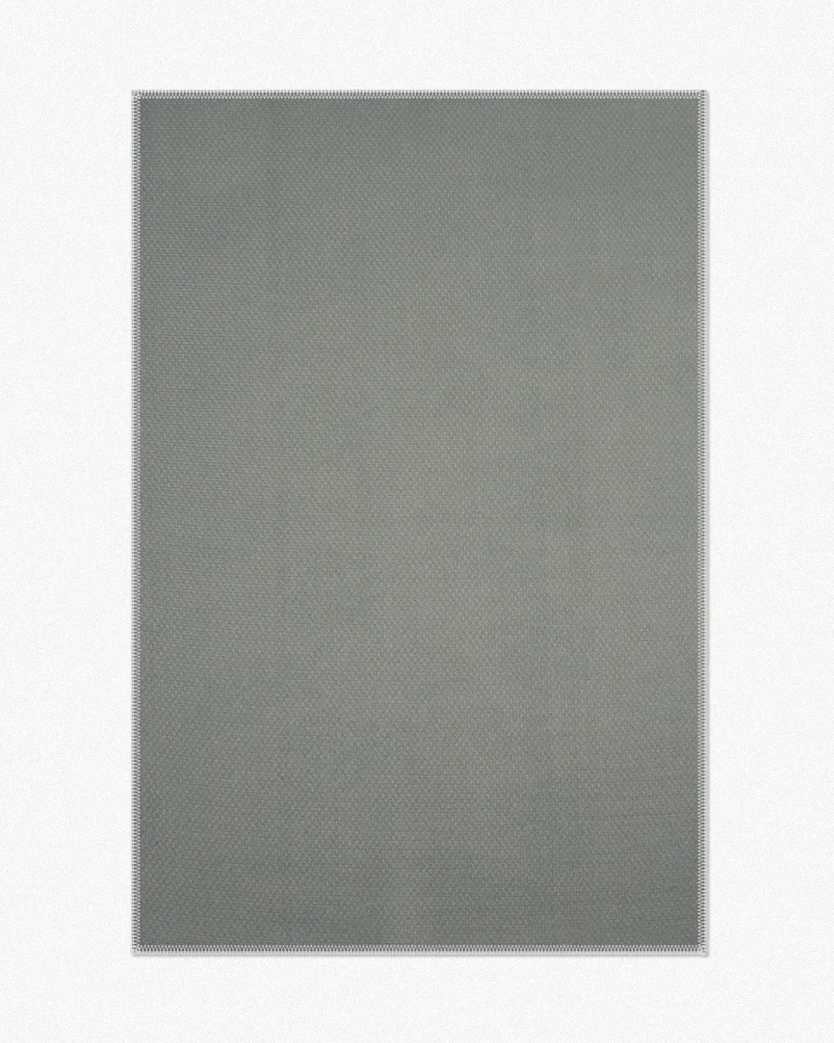 Nook Decor offers a detailed look at the back of our eclectic area rug, designed for both indoor and outdoor use. It features a no-skid polyester backing, which helps to prevent slipping and sliding, ensuring safety and stability.