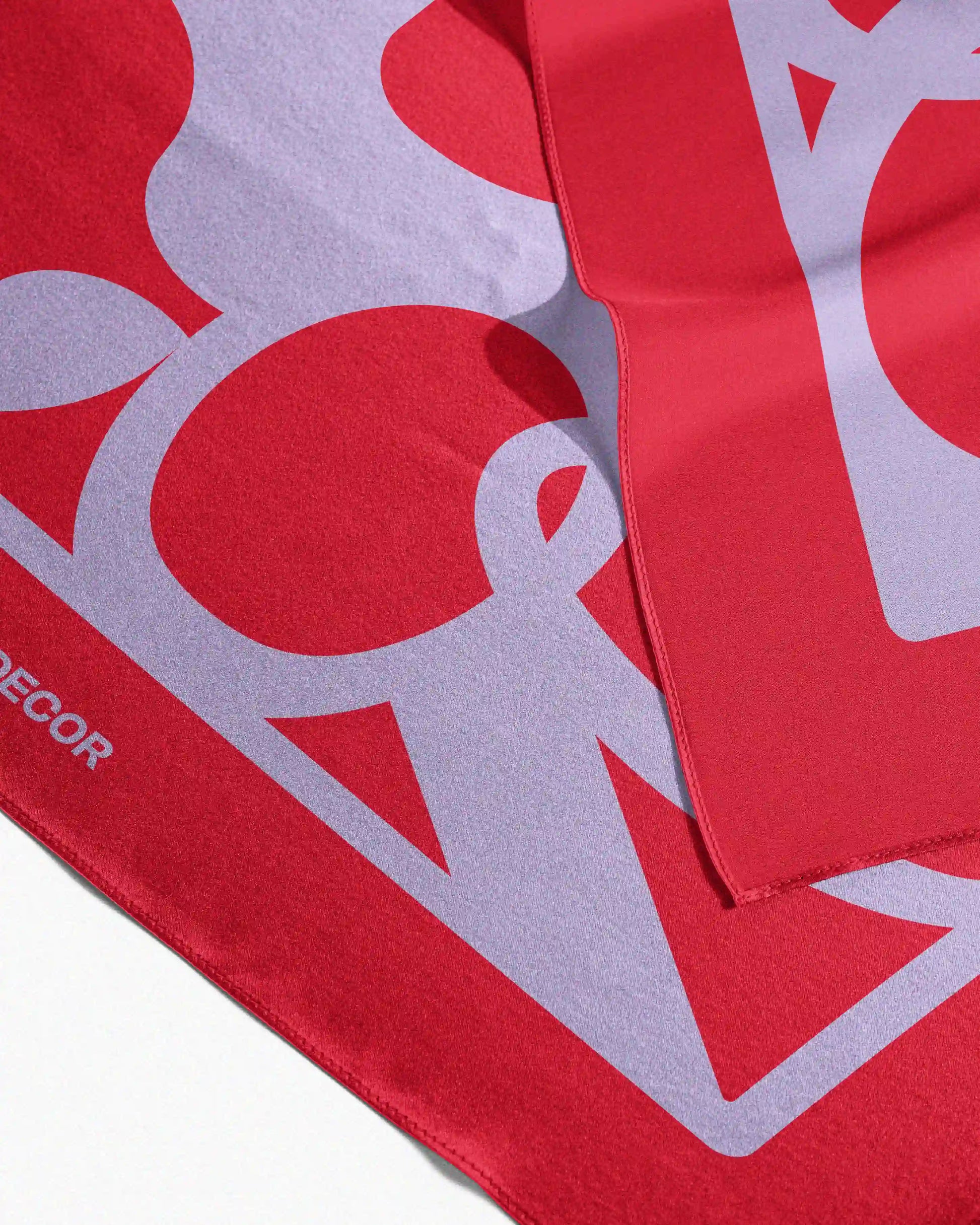 This versatile red and purple mulberry silk scarf is neatly folded on a beige background, showcasing its precise edge binding and elegant structure, perfect for use as a sophisticated waist scarf, bandana, handkerchief, trendy cropped top, Twilly, or table placemat.