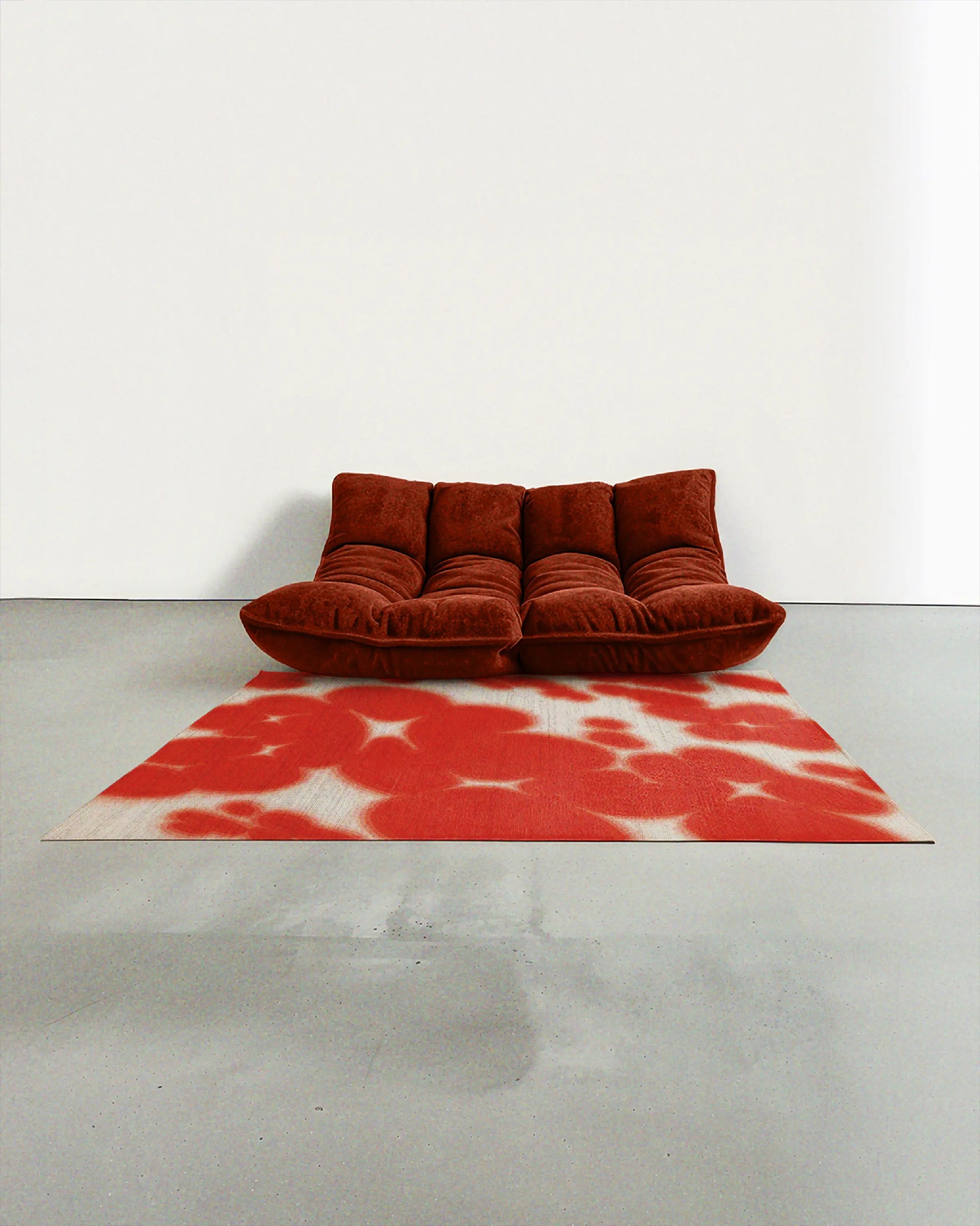 Modern burgundy togo sofa on mid century modern style decorative abstract area rug, with red and cream white hues, animal prints resembling cowhide pattern, faux wool low pile rug in a minimalist, Scandinavian living room.