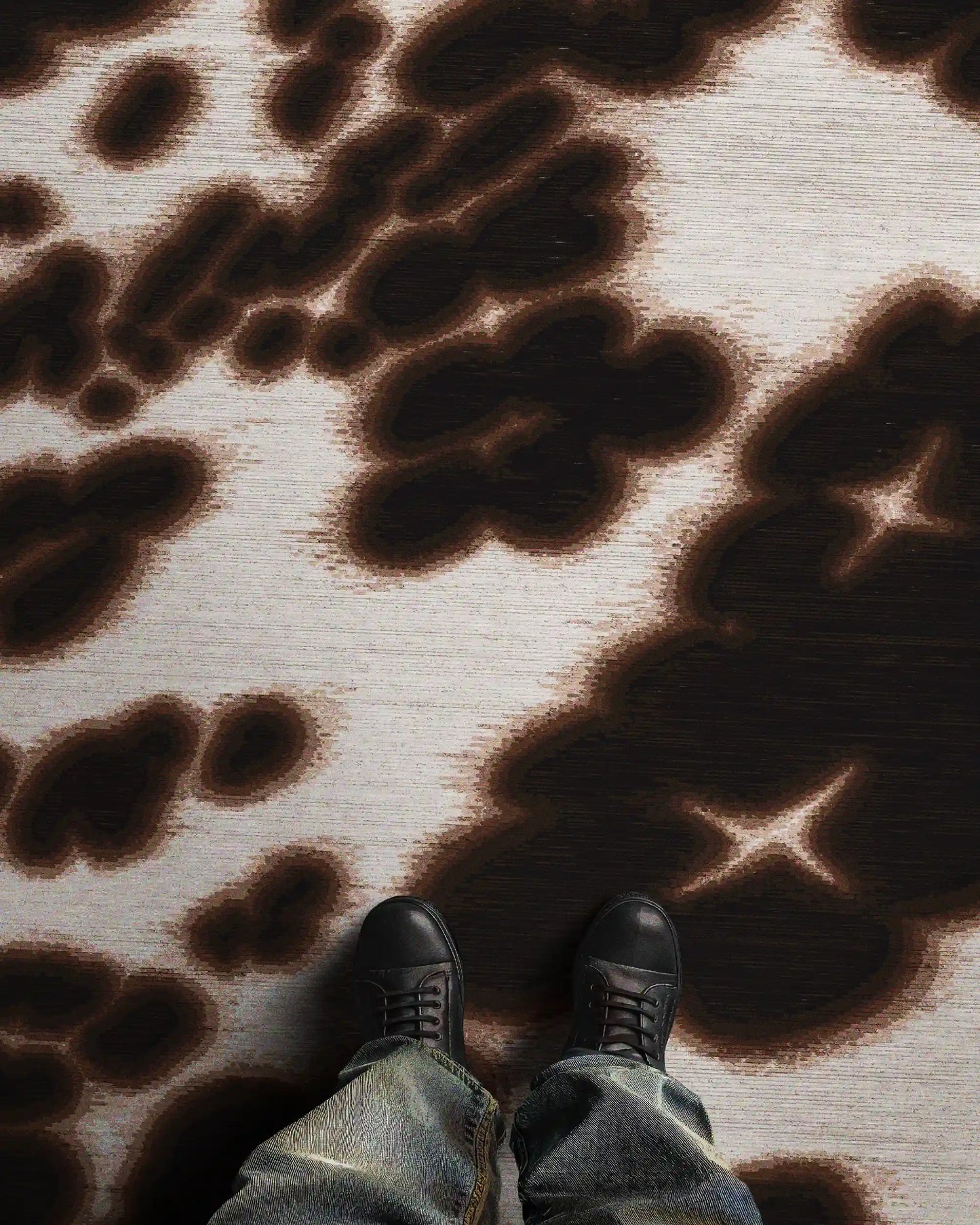 A man standing in an eclectic home decor, featuring the dopamine and bold, dark brown floral cowhide area rug, size 8x10 ft.