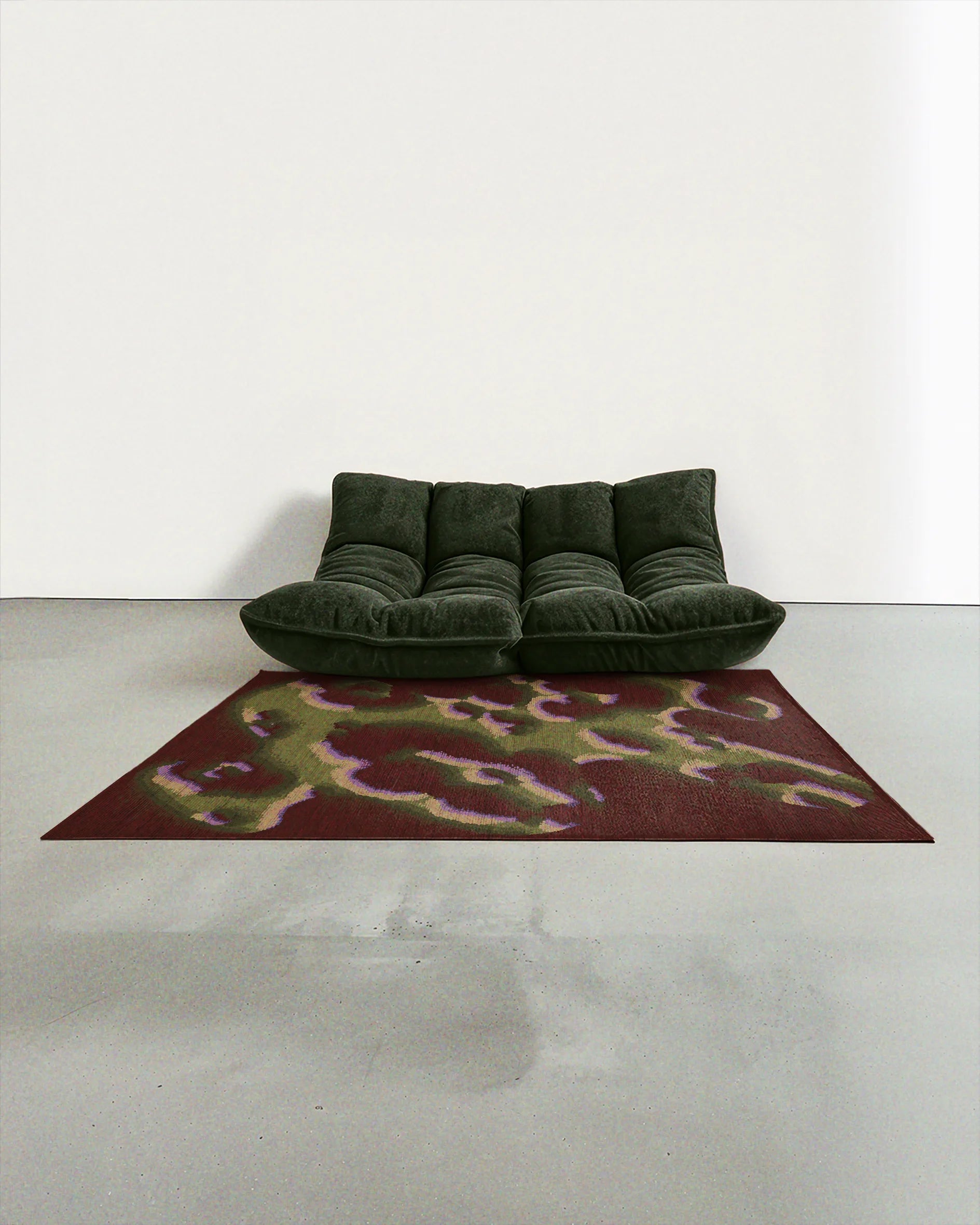 A dopamine abstract camouflage area rug 5ft x7ft, in burgundy and olive green, placed in a contemporary studio with a dark green 2 seats sofa.