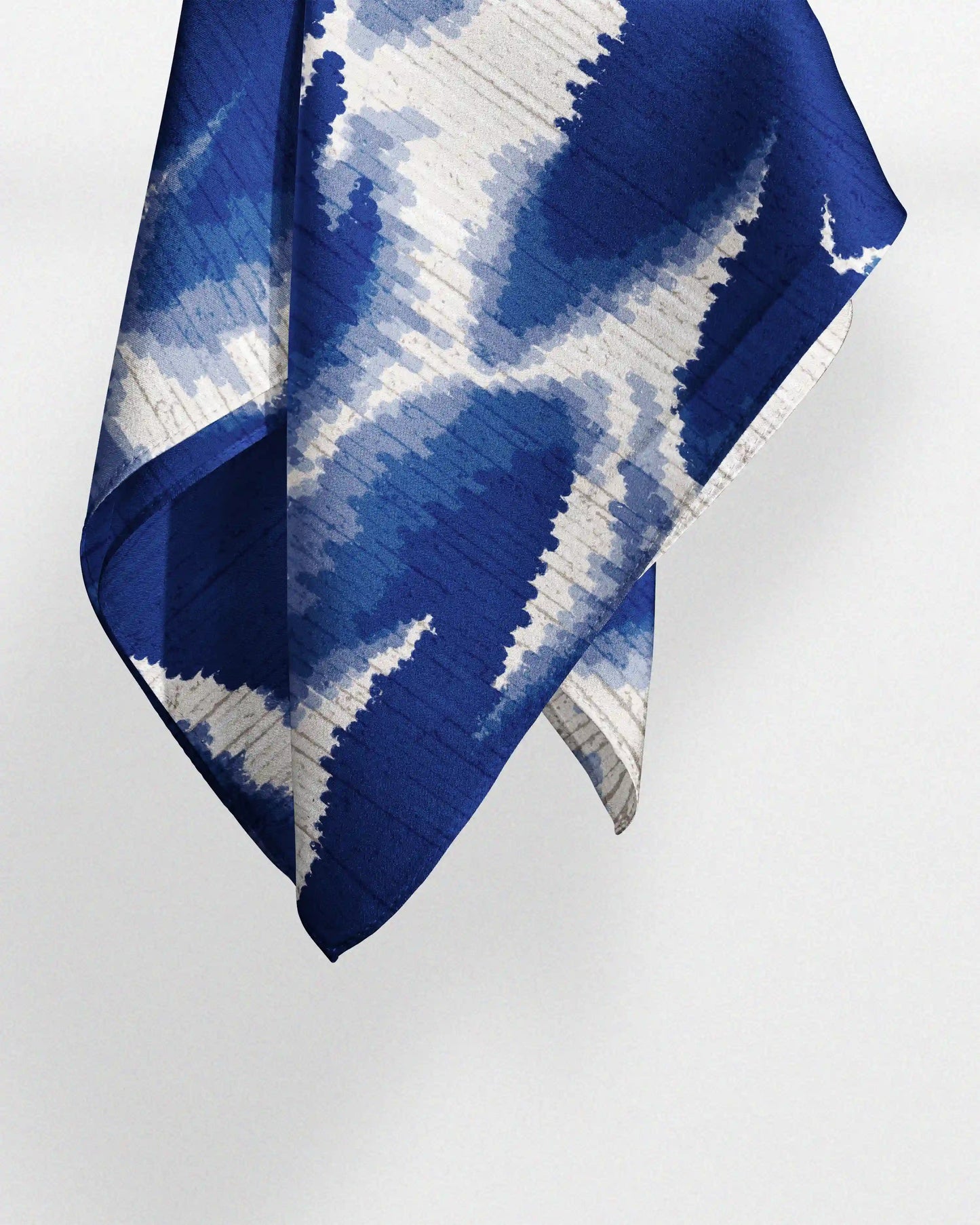 A luxurious 100% mulberry silk scarf arranged to show its abstract fish and floral pattern and its multi functional use as waist scarf, handkerchief, bandana or even dopamine decorative table placemat.