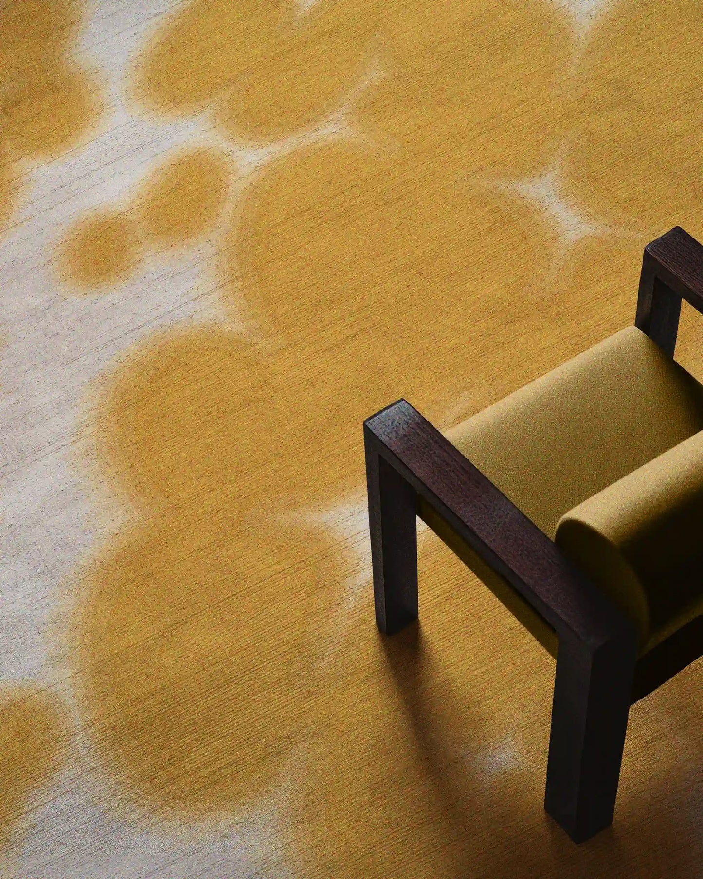 A large 9x12 ft yellow and off white floral cowhide area rug placed underneath a yellow wooden air chair, a dopamine home decor item for an eclectic aesthetic apartment.