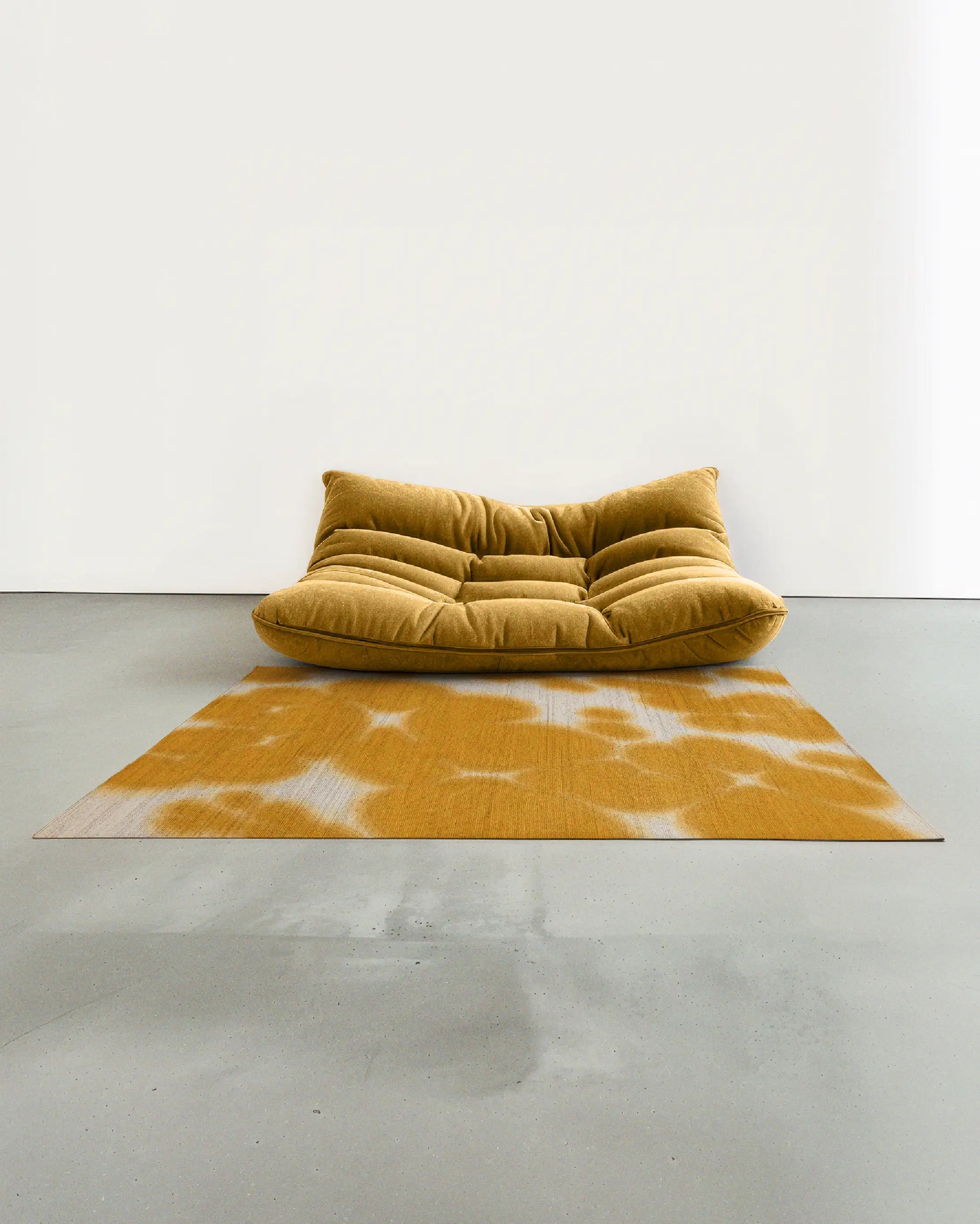 Cowhide floral Aura area rug 5x7 ft, in yellow and off white hues, artfully placed in a contemporary studio with a yellow togo sofa.