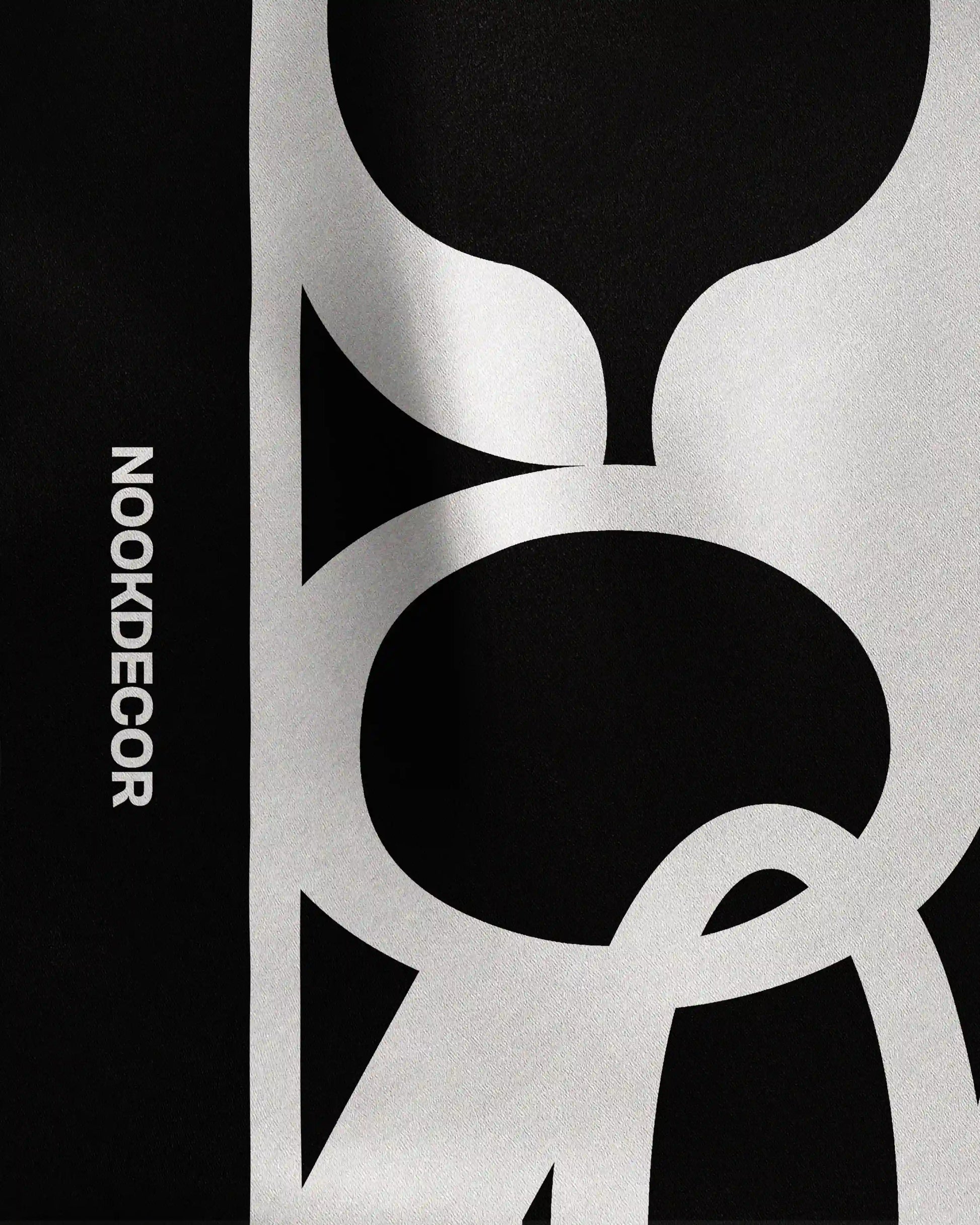 Detail of the intricate NOOKDECOR’s logo design on this 100% mulberry silk bandana in black and white, highlighting its quality as a luxury and chic twilly scarf and statement colorful accessory.