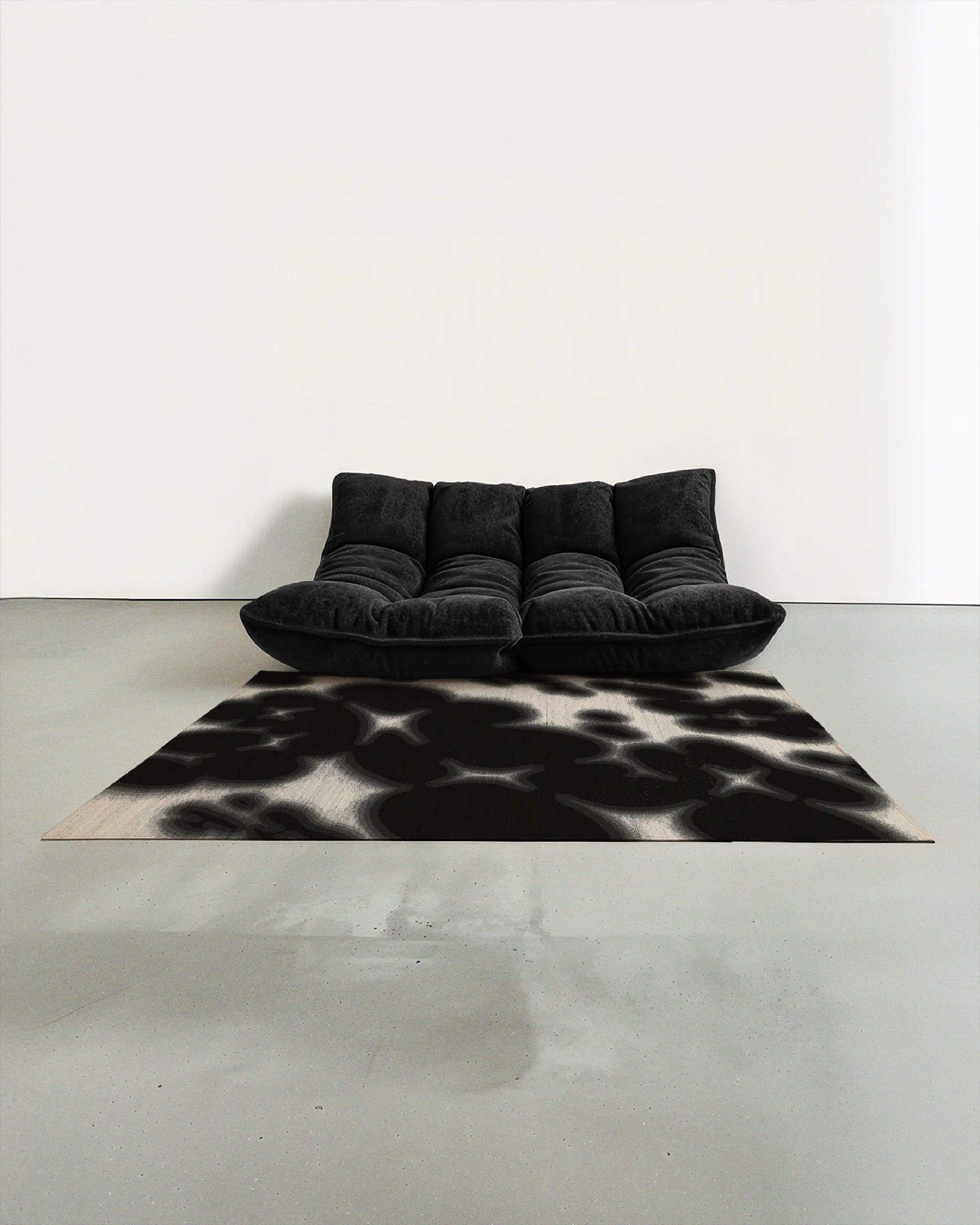 Cowhide floral Aura area rug 5x7 ft, in black and off white hues, artfully placed in a contemporary studio with a dark grey togo sofa.