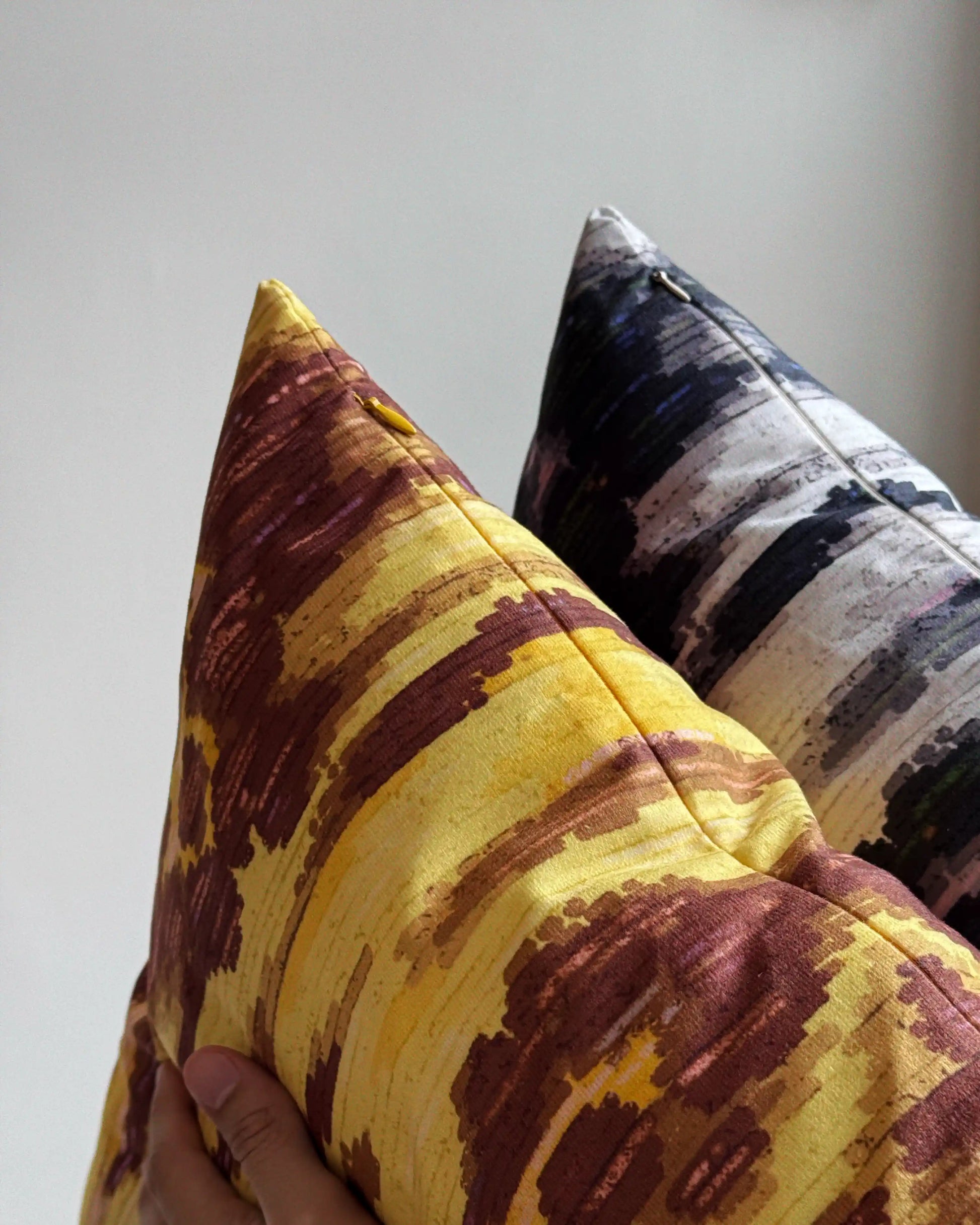 Close-up of hidden zipper closure in yellow and cream white on set of two abstract floral leopard cushion cover, include yellow and brown variant and dark grey and off white, showing easy insertion and premium construction details.