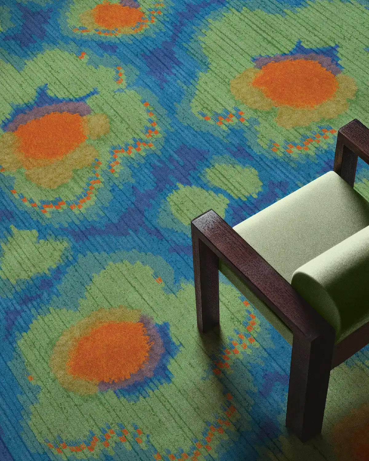 The Bright colored area rug with cute floral patterns in Klein blue, green and orange is placed underneath the mint chair in a cozy apartment.
