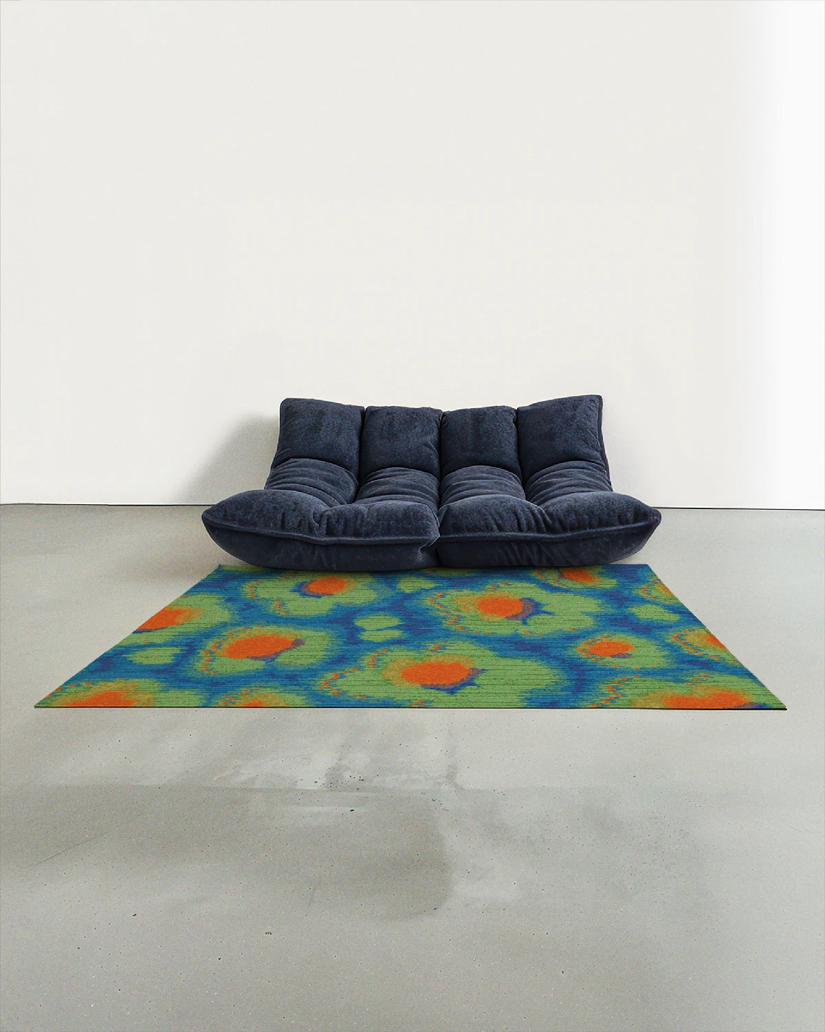The bright colored area rug 5x7 in Klein blue, green and orange hues is placed in the modern studio with a navy Togo sofa.