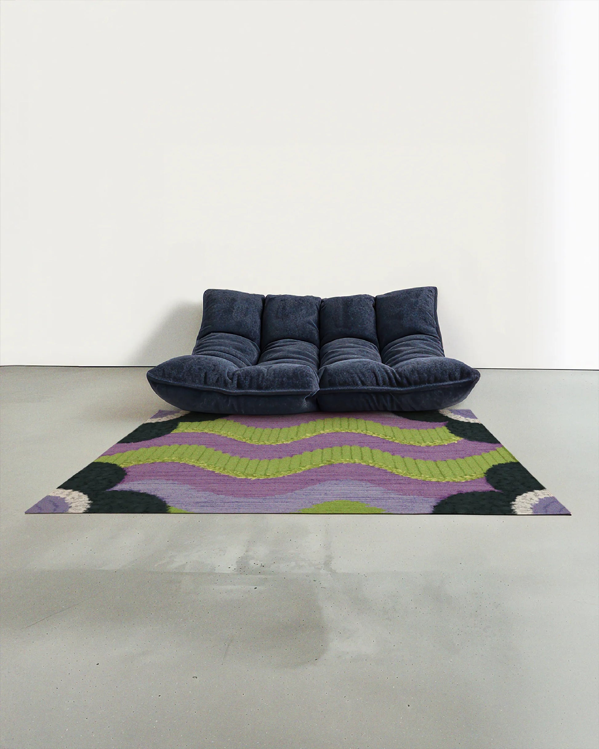 Floral area rug 5x7 with a geometric poppy and waves pattern in green and purple, placed in a modern studio with a navy Togo sofa.
