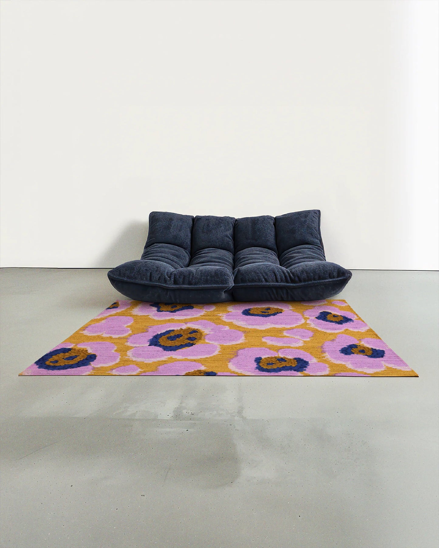 Purple and yellow eclectic floral area rug placed in a modern studio with a navy Togo sofa for maximalist home decor lovers.