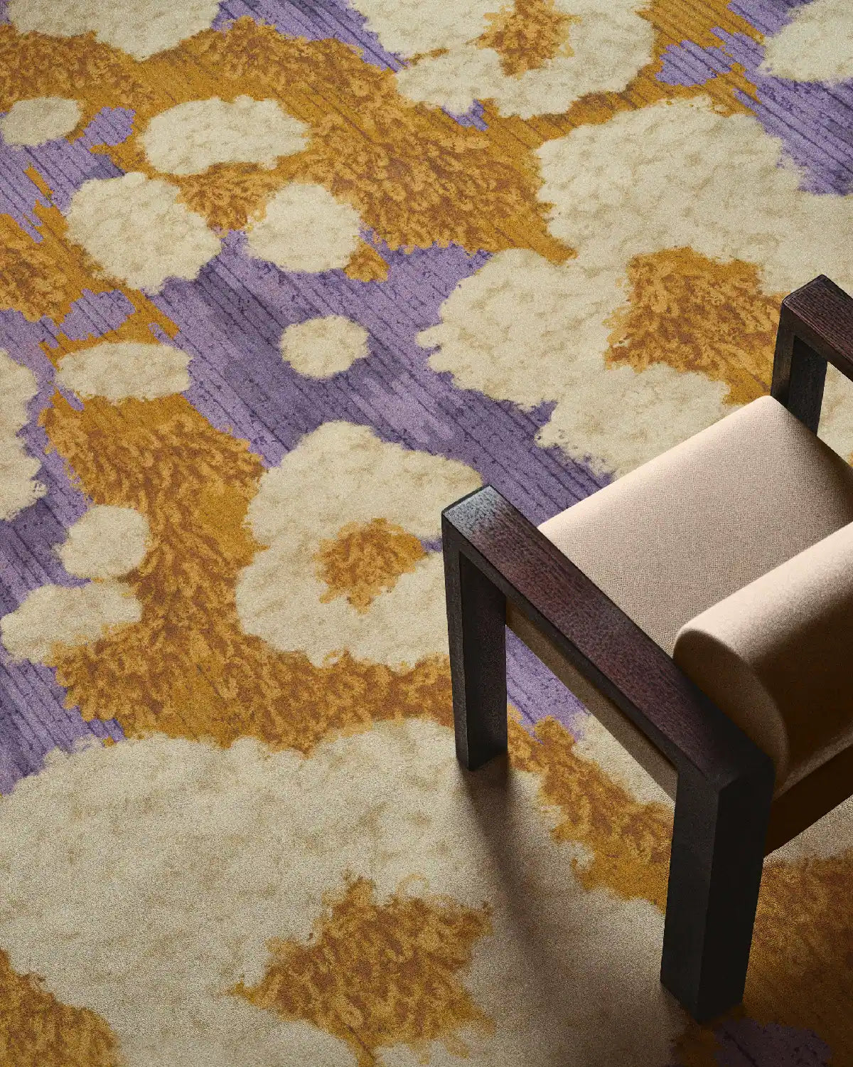 Colorful area rug 8x10 with cute and abstract yellow and purple popcorn patterns placed in a maximalist home with a cream chair.