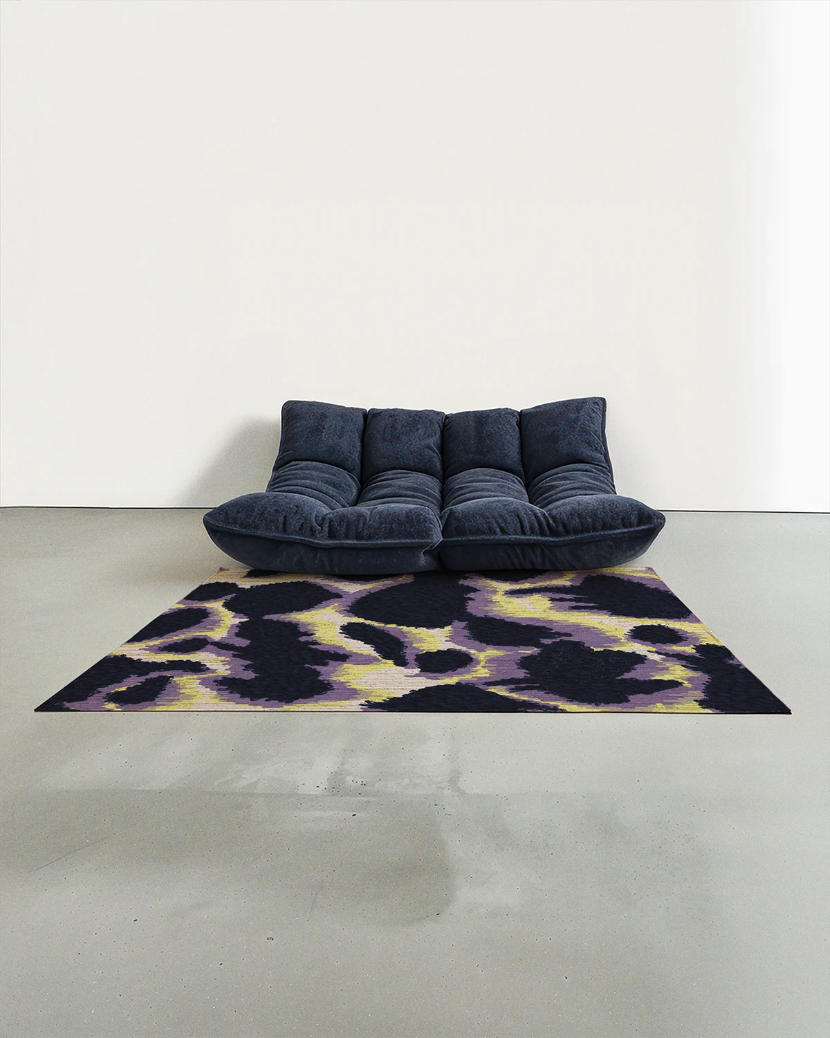 Purple and yellow cowhide rug 5x7 placed in a mid century modern studio with a navy Togo sofa.