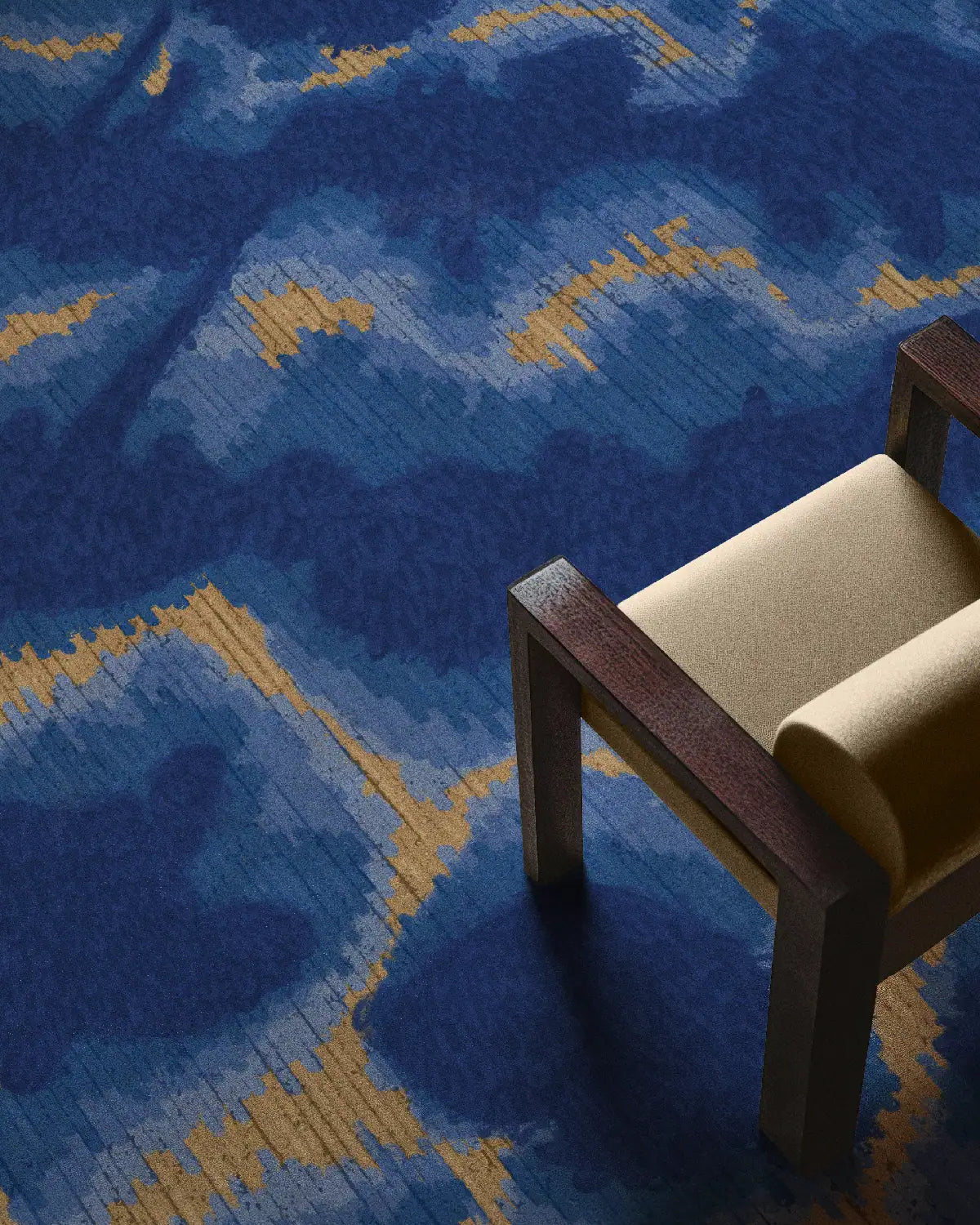 Modern area rugs 8x10 with abstract aura design in Klein blue and sand beige placed underneath the beige chair in a mid century modern living room.