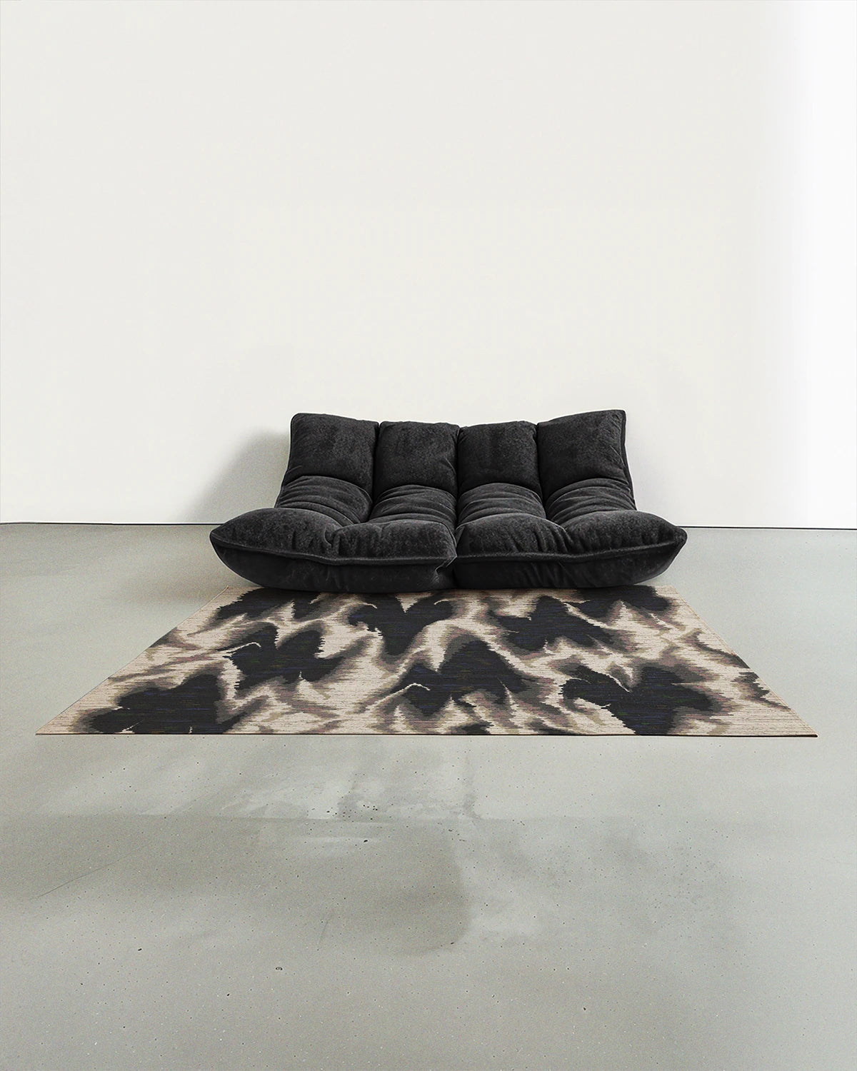 The grey black and white aura Scandinavian rug 5x7 placed in a mid century modern studio with a grey Togo sofa.