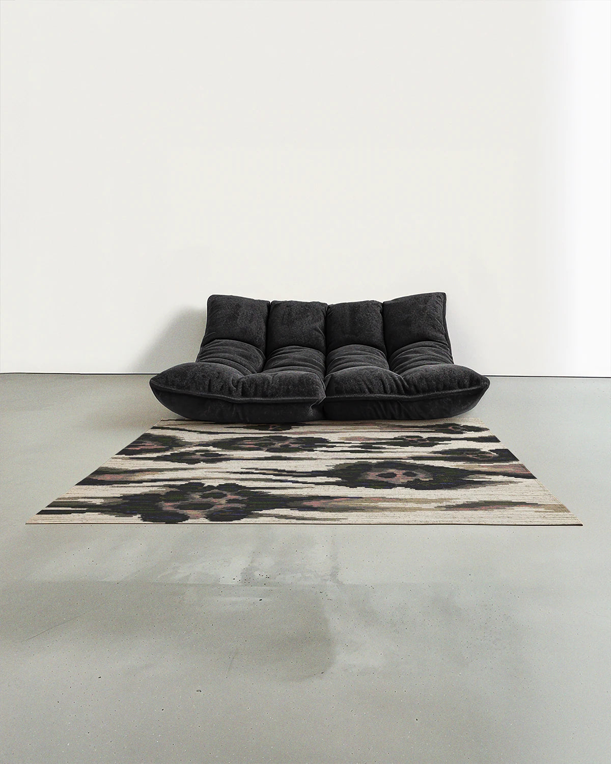 Floral area rug 5x7 with a leopard pattern in black, white, and beige is placed in a mid century modern studio with a grey Togo sofa.