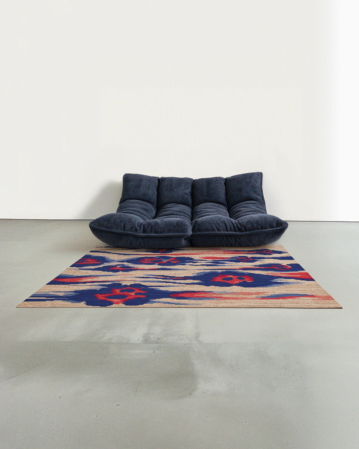 Floral area rug 5x7 with a leopard pattern in coral red, blue and beige is placed in a modern studio with a navy Togo sofa.