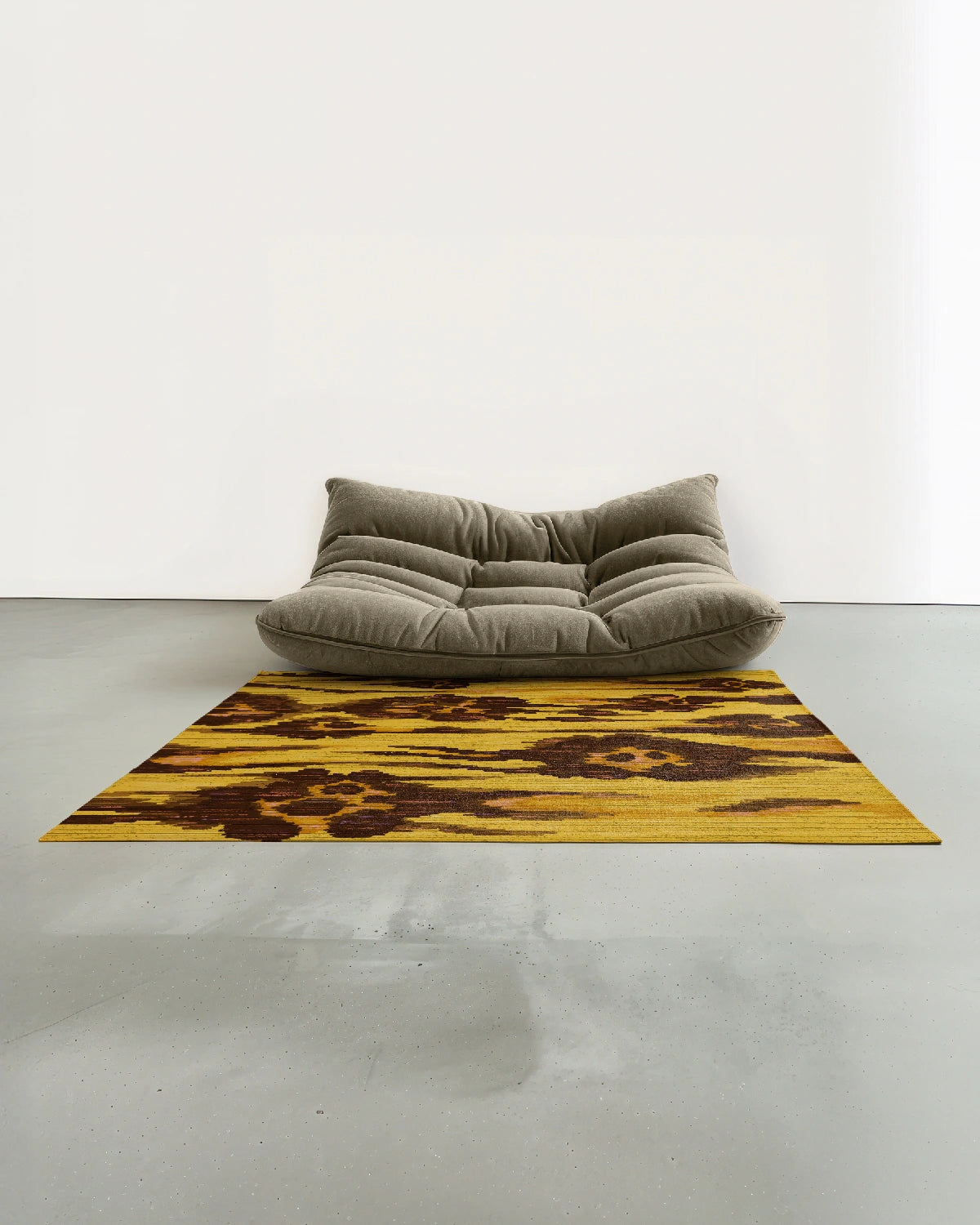 Floral area rug 5x7 with an abstract leopard pattern in yellow and brown, placed in a modern studio with a dusty beige togo sofa.