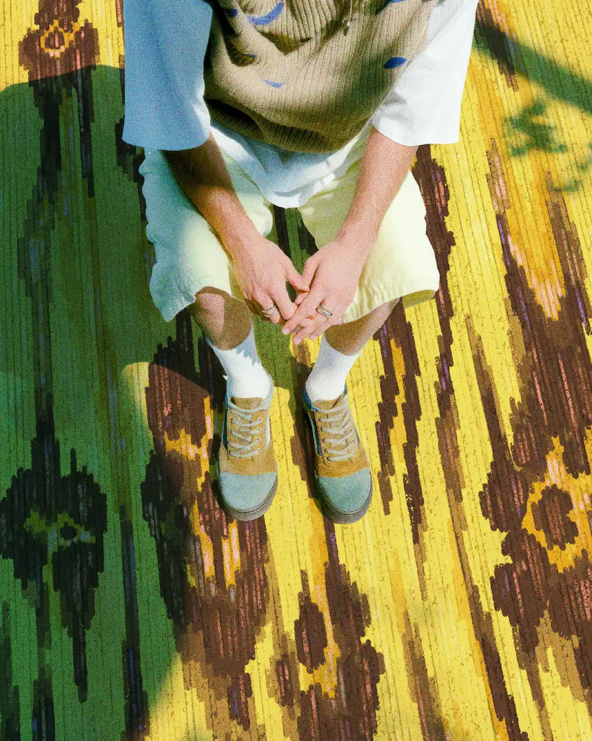 Man relaxing on the leopard floral area rug 8x10 with cozy earth tone outfit in a modern living room.