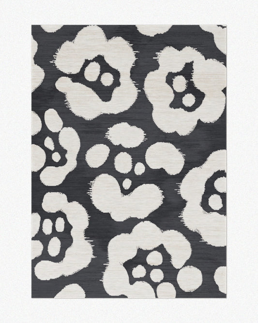 Area rug 5x7 with floral patterns and black and off white hues set against a light beige background, highlighting its mid century modern aesthetic.