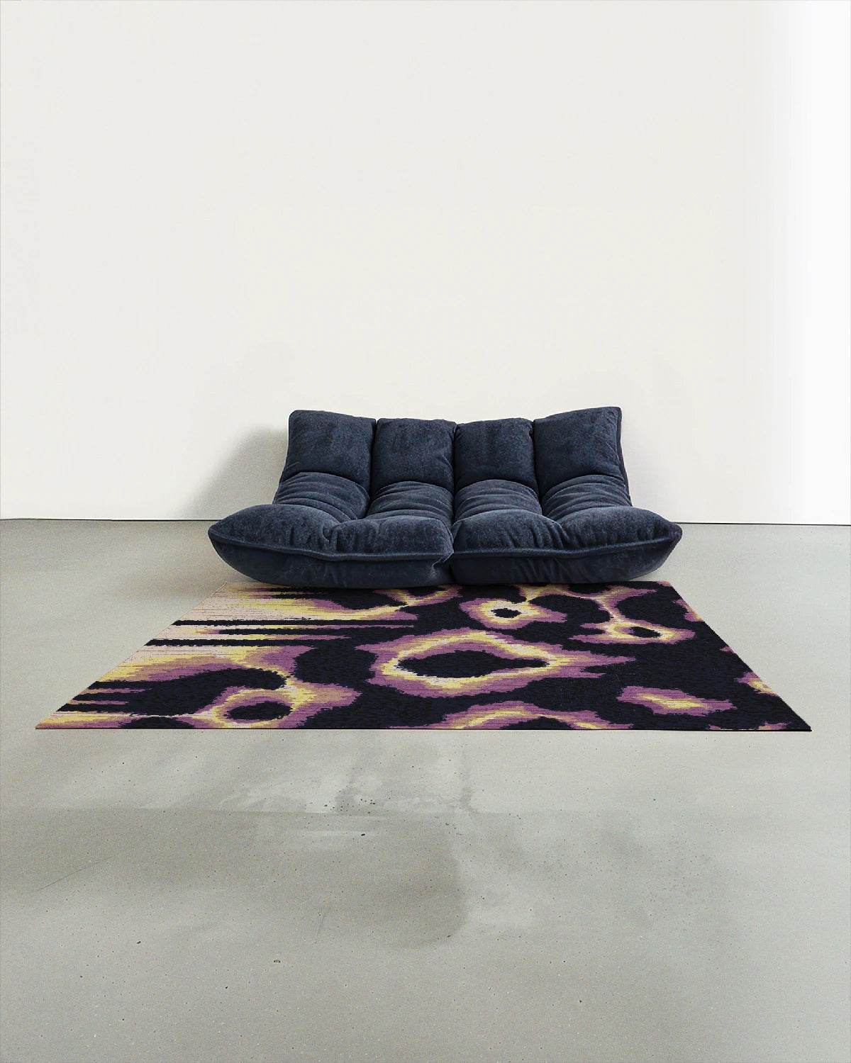 Purple and yellow leopard rug 5x7 placed in a modern studio with a navy Togo sofa.