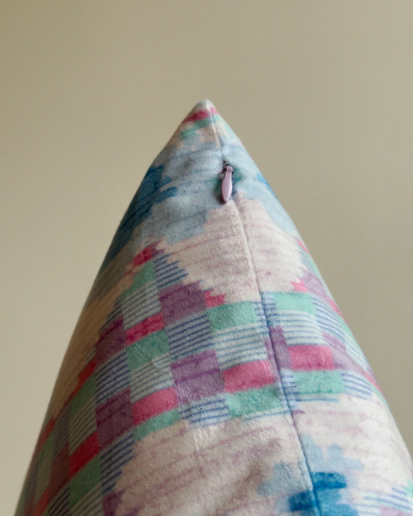 Close-up of hidden zipper closure in pastel purple on pastel purple, light green and blue floral checkered cushion cover, showing easy insertion and premium construction details.