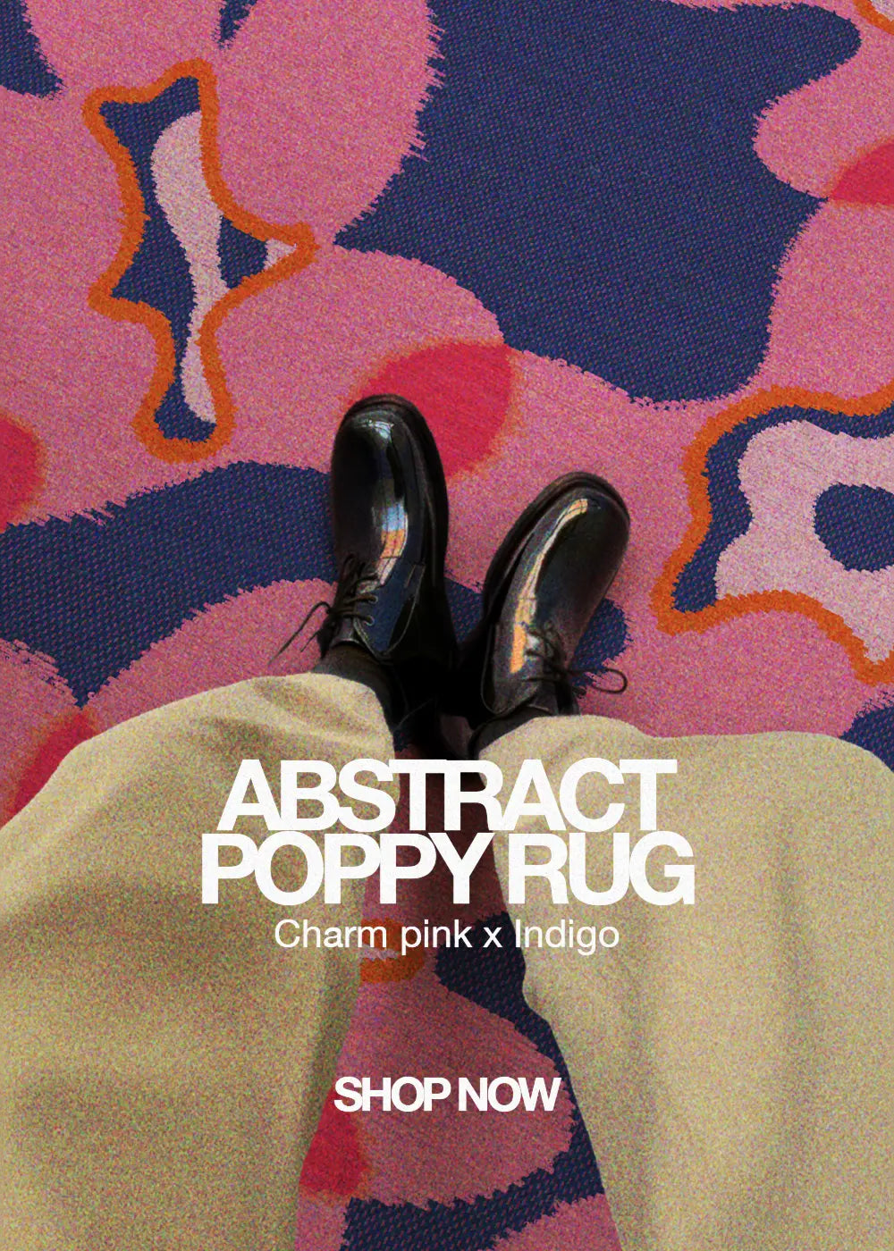 Homepage banner, mobile version of a man wearing black leather shoes and beige pants is resting his leg on a large pink and dark blue floral area rug.