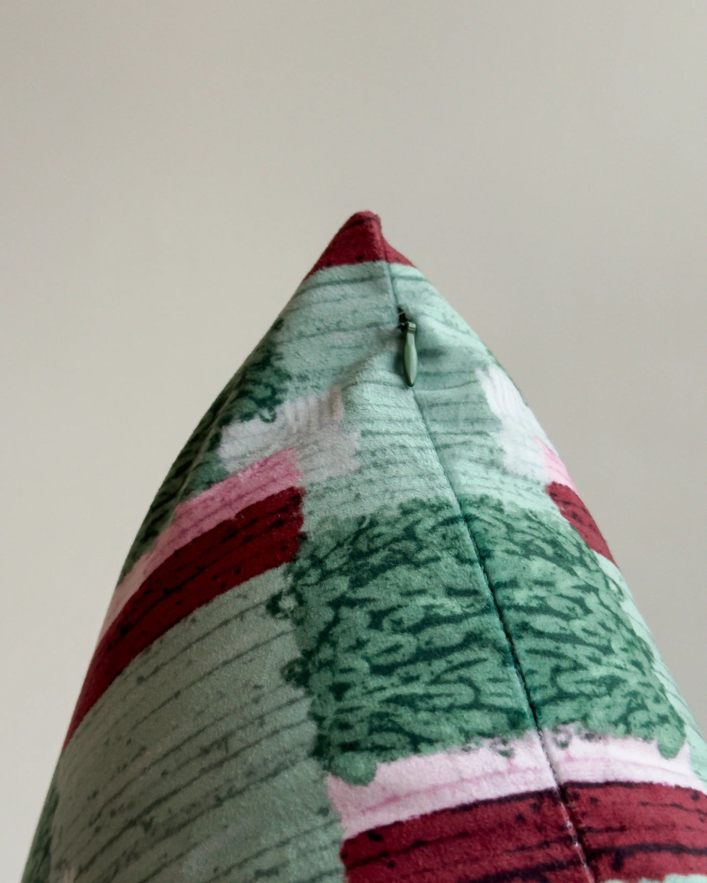 Close-up of hidden zipper closure in olive green on dark green, light green and pink checkered cushion cover, showing easy insertion and premium construction details.