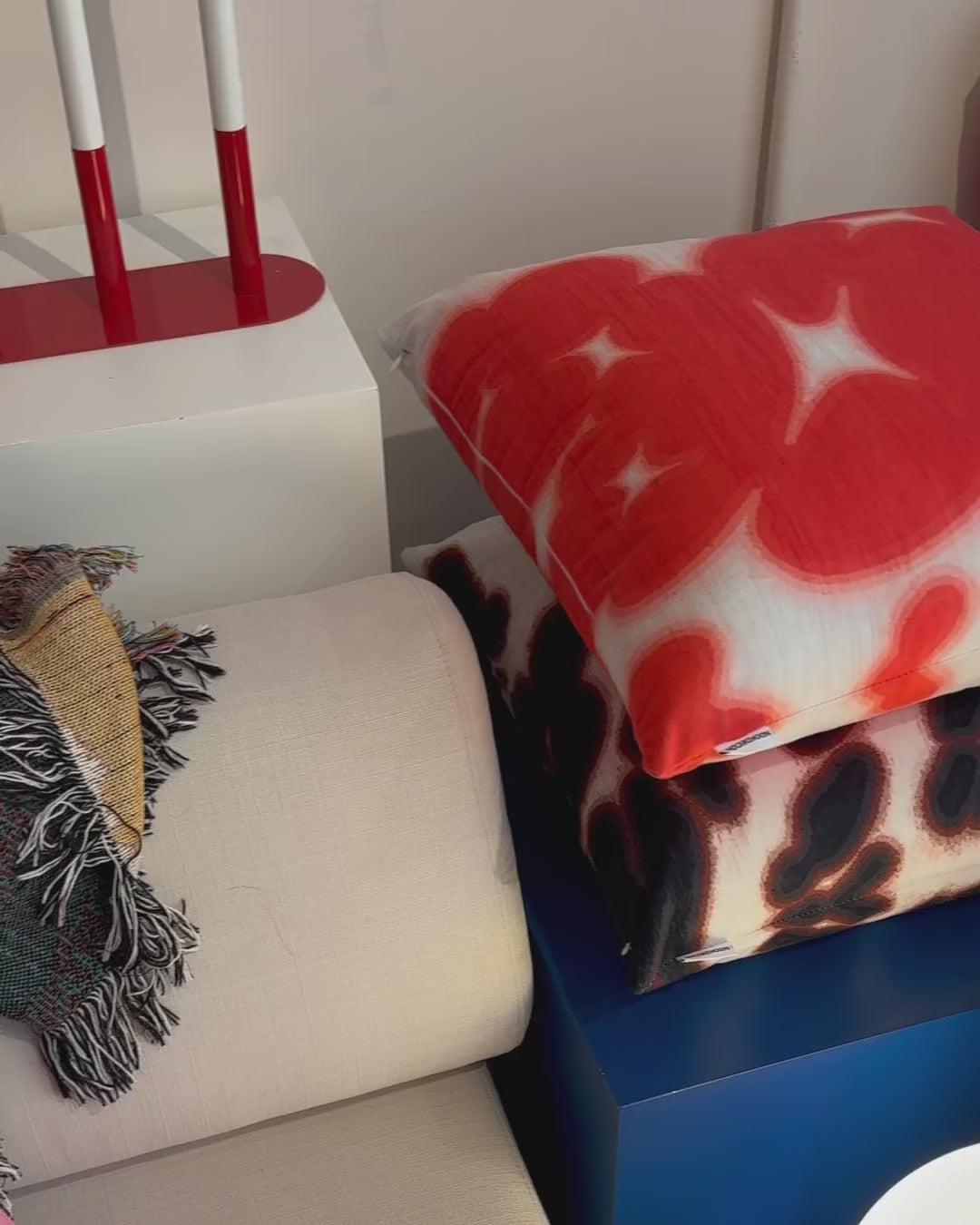 Product video of red white and brown white floral cushion, throw pillow in eclectic studio. Dopamine home decor for maximalist apartment.