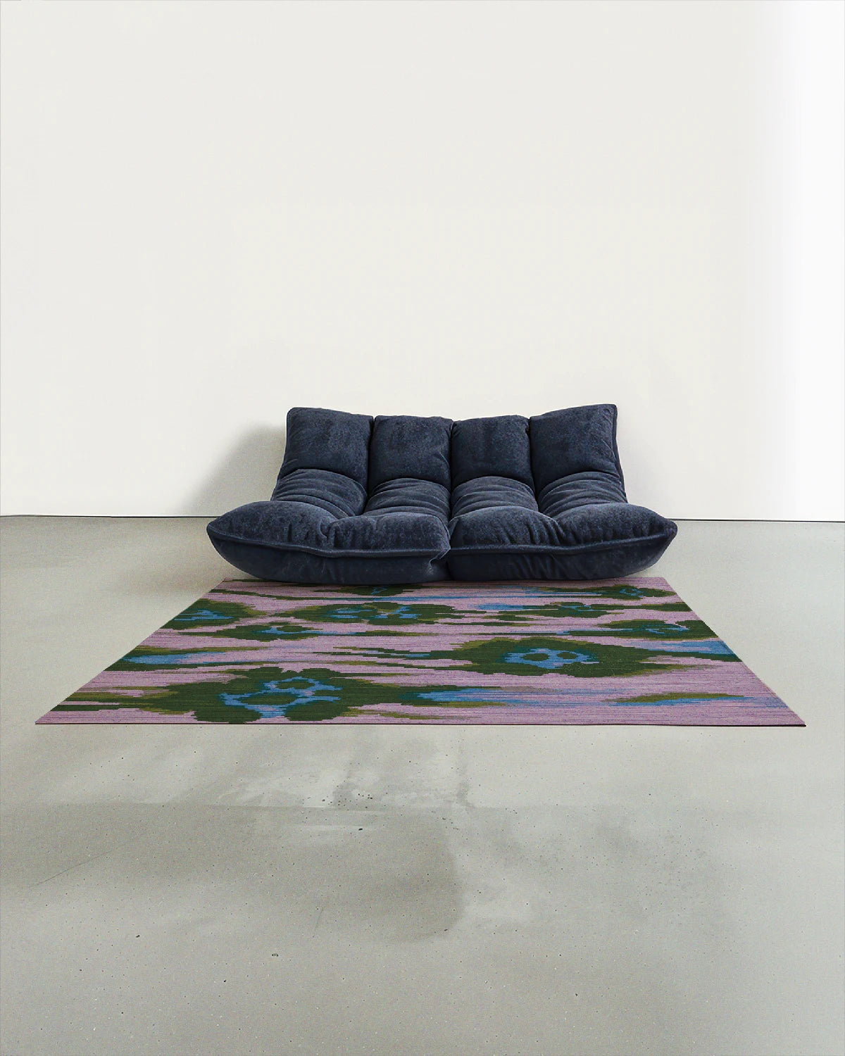 Coquette, colorful area rug 5x7 with abstract leopard patterns in purple, blue, and green, is placed in a modern studio with a navy Togo sofa.